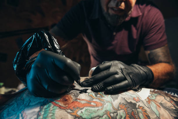 istock Tattoo artist creating a tattoo 1309819385