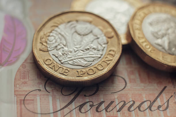 istock British one pound coins placed on top of 10 pounds banknote. 1309820951