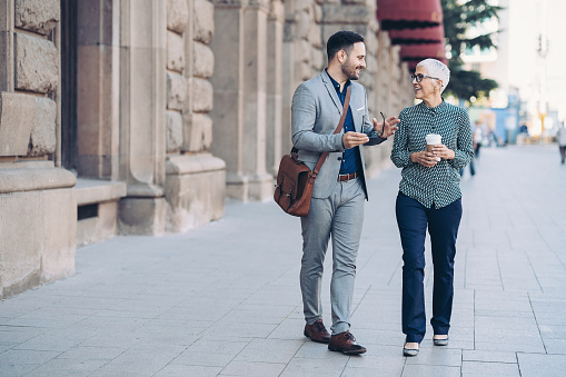 Two business persons walking together and talking