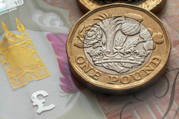 британские монеты один фунт размещены на вершине 10 фунтов банкноты. - one pound coin coin pound symbol falling стоковые фото и изображения