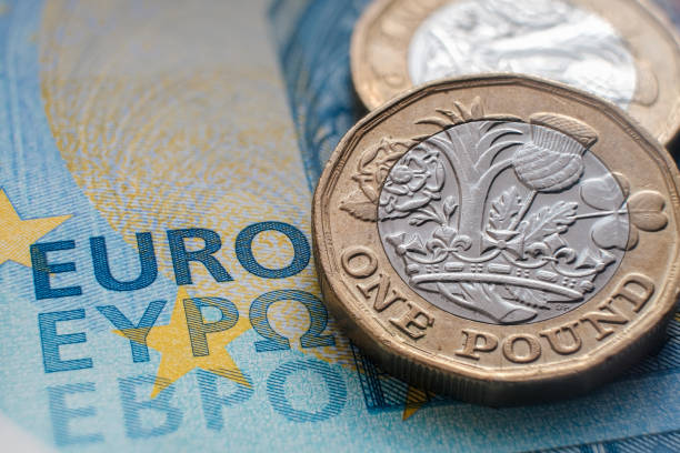 20ユーロ紙幣の上に置かれた英国の1ポンド硬貨 - british coin coin falling british currency ストックフォトと画像