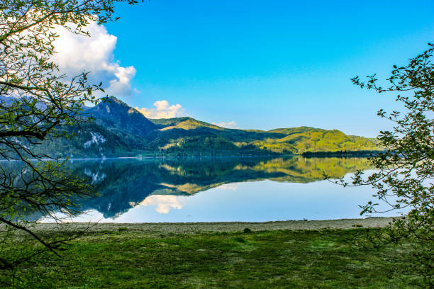 istock Mirror lake in front of green mountain 1309821031