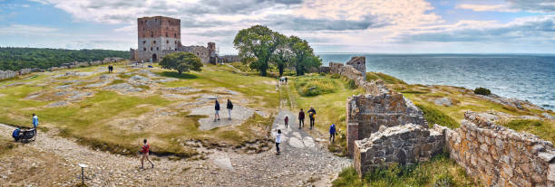 touristes visitant les ruines du château de hammershus - la plus grande fortification médiévale de scandinavie. - hammershus photos et images de collection