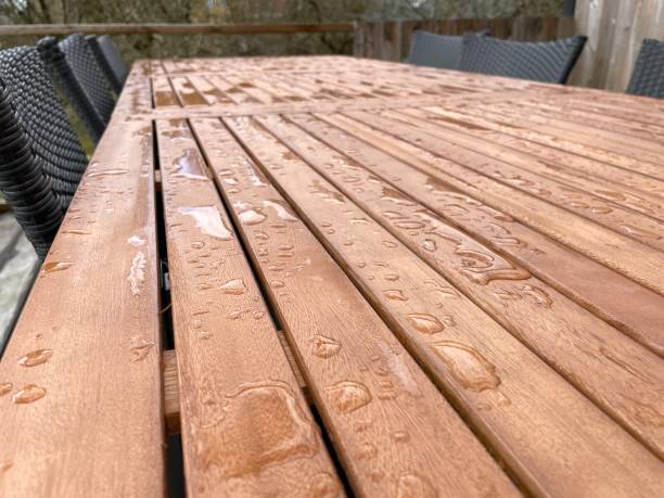 istock Wooden table with water on it 1309821701