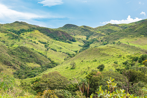 Landscape of a hill with vibrant green vegetation on a beautiful day. Mountainous terrain with reliefs. Nature of Minas Gerais state at São Roque de Minas, MG, Brazil.