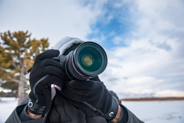 istock man holding camera in snowy nature 1309824414