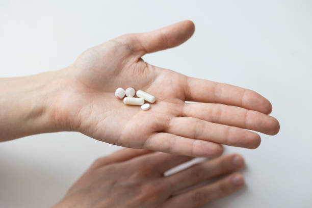 istock a woman's hand with pills in the open palm 1309828169