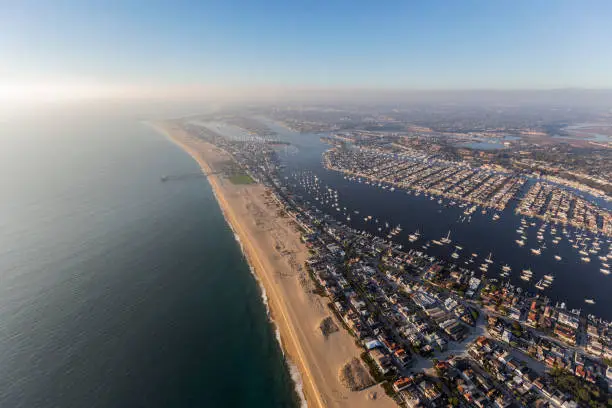 Aerial view of Newport Beach bay and harbor with afternoon pacific ocean fog rolling in.