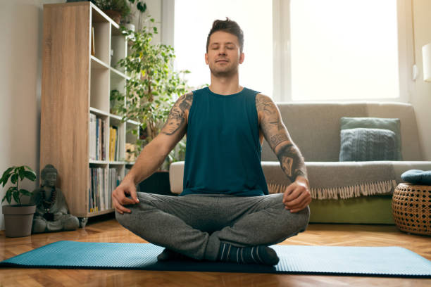 istock Young man meditating at home 1309834991