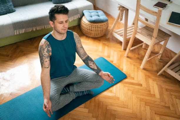 istock High angle view of a young man meditating at home 1309834996