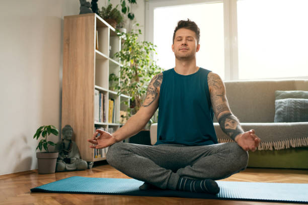 istock Young man with his eyes closed relaxing and practicing breathing exercises 1309834998