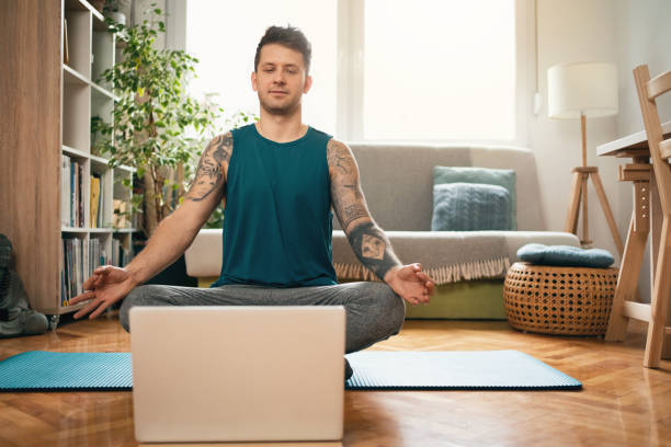 istock Front view of a man with laptop practicing meditation 1309835002