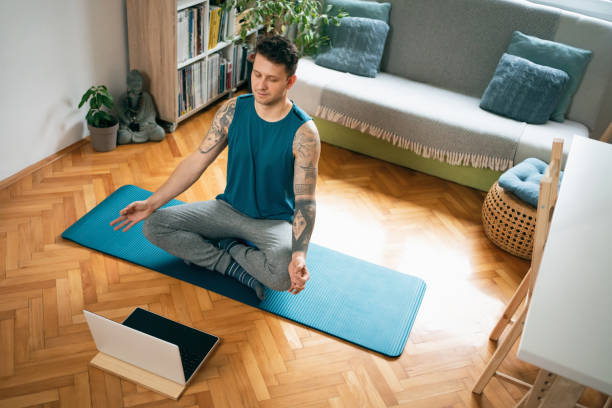 istock High angle view of a young man with laptop practicing meditation 1309835007