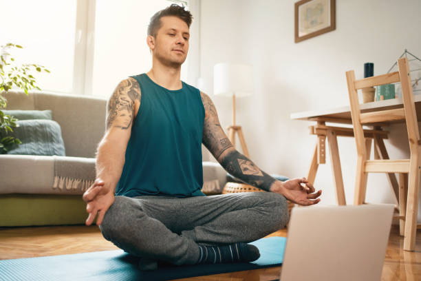 istock Young man in an online class practicing  breathing exercises at home 1309835010