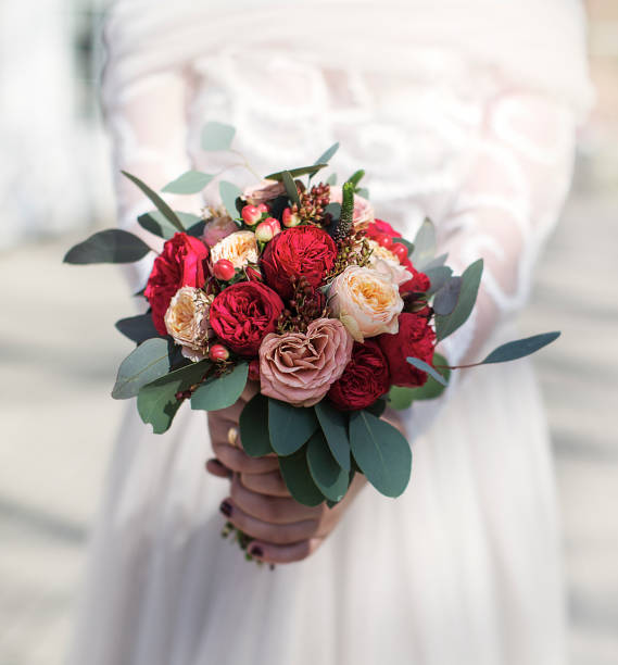 istock Newlywed bride holding beautiful wedding flowers in hands 1309835111