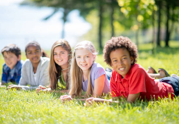 istock Multi Ethnic Group Of Children Smiling While Lying On The Grass Outdoors 1309836170