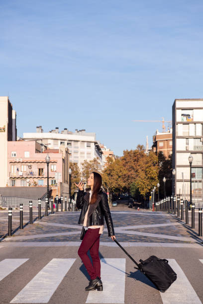 istock woman pulling suitcase recording a voice message 1309836250