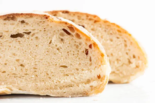 Detailed closeup of baked sourdough artisan bread with a rustic crust and high water hydration.