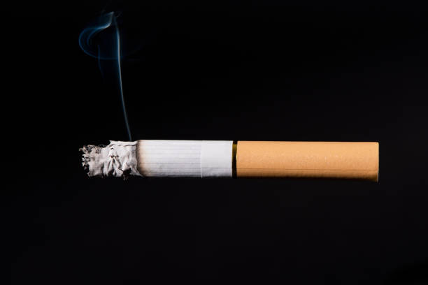 istock Cigarette smoking closeup isolated on balck background 1309844436