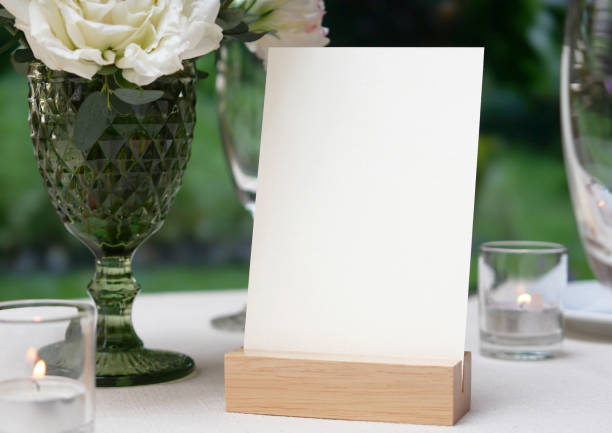 istock Mockup white blank space card, for greeting, table number, wedding invitation template on wedding table background. with clipping path 1309844650