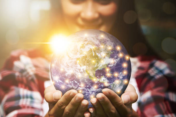 istock A woman's hand holding a globe and there is a light spot that is connected in a network. 1309846457
