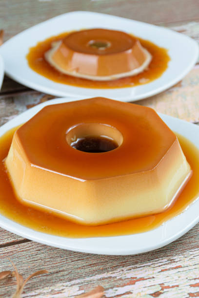 istock Condensed milk pudding with caramel syrup. Dulce de leche pudding in the background. Brazilian traditional sweets (vertical photo). 1309847818
