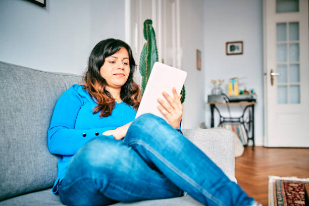 istock Relaxed Woman Using Digital Tablet In Living Room 1309848497