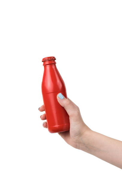 istock A woman's hand holds a red glass closed bottle isolated on a white background. 1309848658