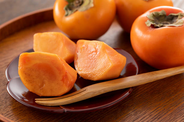 Multiple persimmons lined up on the tableMultiple persimmons lined up on the table Multiple persimmons lined up on the tableMultiple persimmons lined up on the table Persimmon stock pictures, royalty-free photos & images