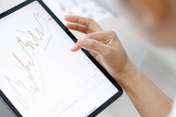 istock Business woman hand holding digital tablet computer with graph of Binary option for trading platform, setective focus 1309855032