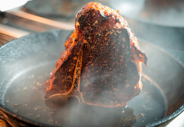 Porterhouse steak frying on cast iron pan