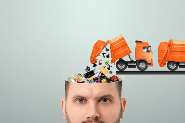 istock Garbage in the head, clogging up the head with unnecessary information. Garbage truck unloads garbage into the head. 1309858666