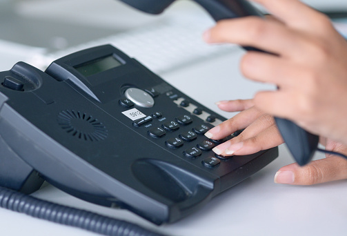 Closeup shot of an unrecognisable woman using a telephone in an office