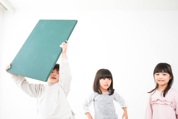 istock Children holding blackboard together on white background 1309865854