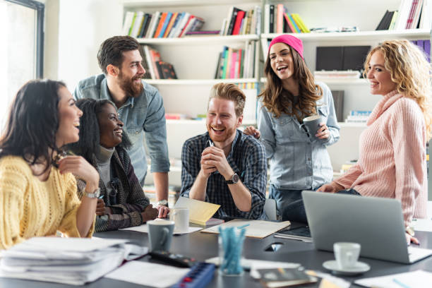 istock Young happy freelancers talking while working at casual office. 1309868171