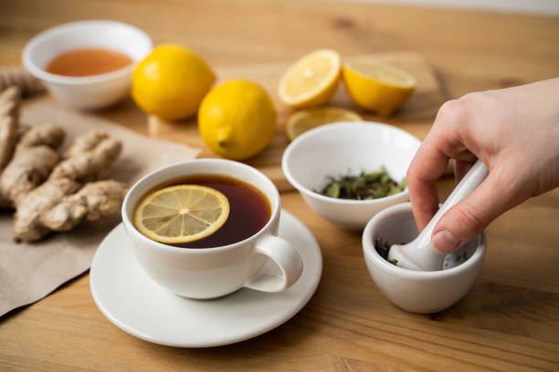 istock Cup of ginger tea with lemon on wooden table 1309868233