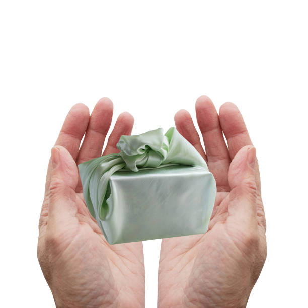 Hands holding a box, a gift wrapped in a delicate satin cloth.