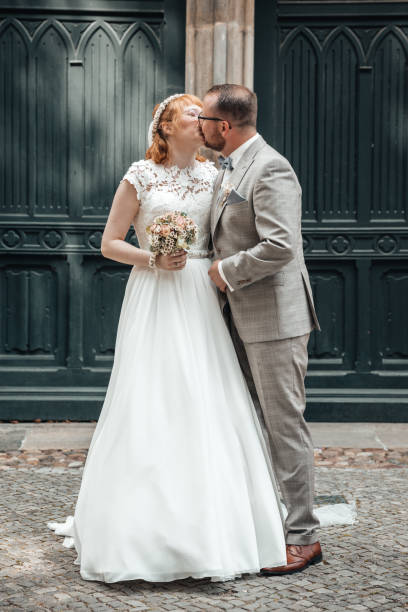 istock Bride and groom kissing on wedding day 1309873942