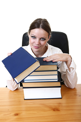 Young business girl in office with books