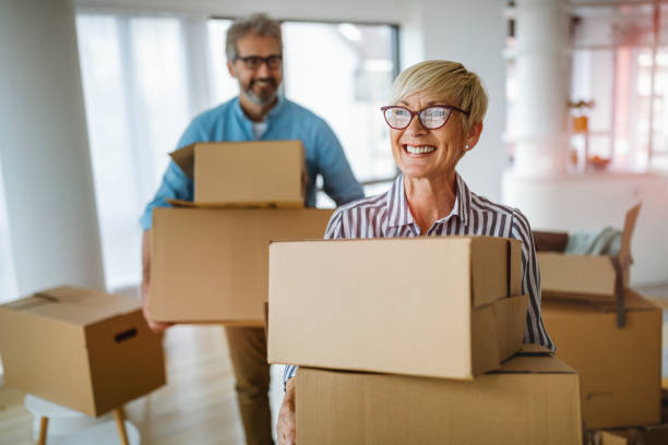 verticale de couples aînés heureux dans l’amour se déplaçant dans la nouvelle maison - déménagement photos et images de collection