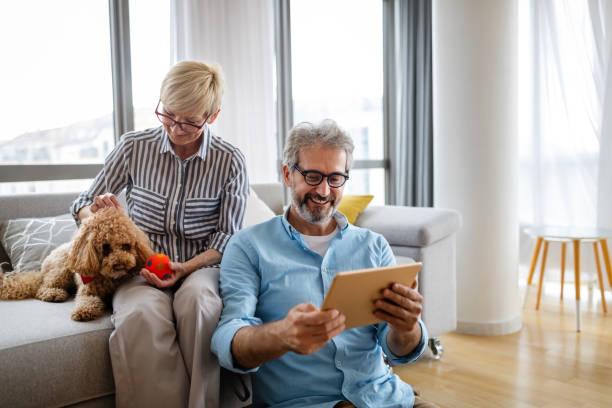 istock Beautiful happy mature couple is using a digital tablet, talking and smiling at home 1309875126