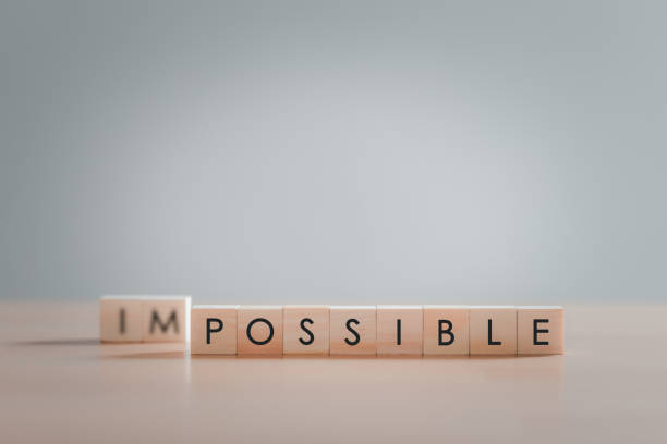 Text "POSSIBLE" on wooden block, Making possible is possible by leaving the impossible behind, Business, success, challenge, motivation, action and reaching goals, achievement and possible concept. Text "POSSIBLE" on wooden block, Making possible is possible by leaving the impossible behind, Business, success, challenge, motivation, action and reaching goals, achievement and possible concept. impossible possible stock pictures, royalty-free photos & images