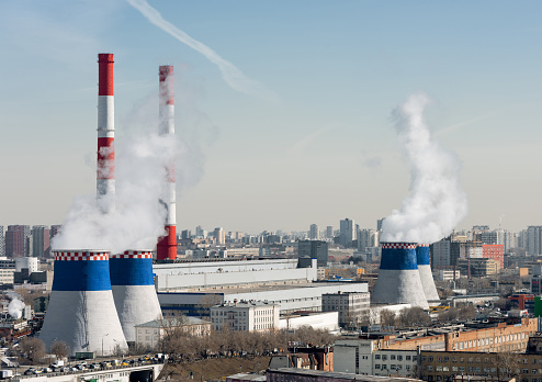 The power plant of a large city. Tall chimneys and cooling towers. Megalopolis landscape