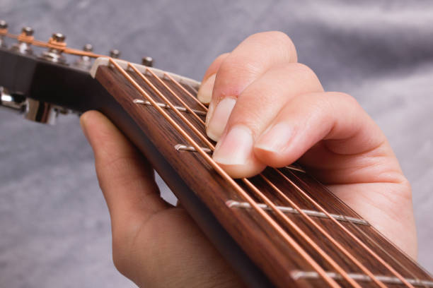 istock Fingers clamping chord on guitar strings closeup 1309877354