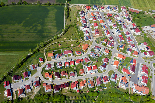 Houses with red roofs in a housing development viewed from above.