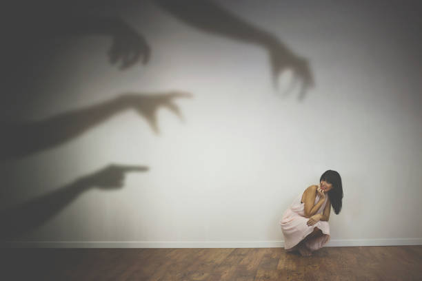 woman frightened by the shadows of hands of demons woman frightened by the shadows of hands of demons phobia stock pictures, royalty-free photos & images