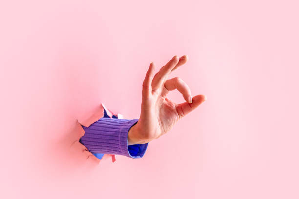 istock woman hand show OK gesture on pink background. 1309880478