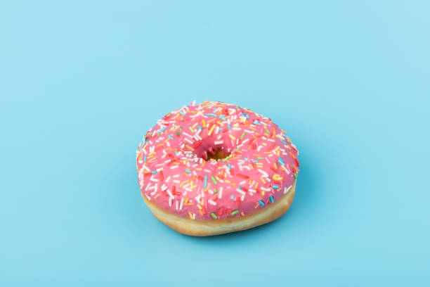 istock Fresh made Donuts isolated on blue background. Doughnuts are traditional sweet pastries. Copy space for text. 1309880545