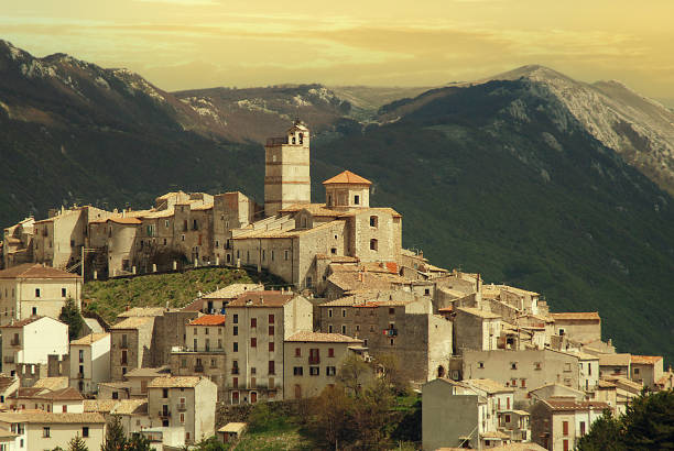 Typical mountain village in Abruzzo, Italy (Gran Sasso mountain range). Sunset Castel del Monte in Abruzzo is a beautiful village which covers the top of a hill in the Gran Sasso mountain range. It is classified as one of the "borghi piu belli d'Italia" or "most beautiful villages of Italy". Its architecture mostly dates to Medieval and Renaissance times. The Medicis ruled the town from 1579 for a century and a half and their legacy includes the Chiesa di San Marco with its distinctive tower. Around the town are strong defensive walls which are also houses and five defensive gates which also date to the Medici period. abruzzi photos stock pictures, royalty-free photos & images