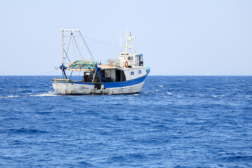 Large fishing boats are sailing in the sea to catch fish.